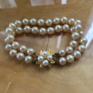 Vintage double-strand pearl bracelet with a gold-tone floral clasp